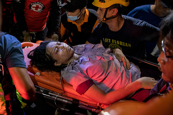 Des ambulanciers paramédicaux emportent un survivant qui a été sauvé des débris d'un immeuble commercial de quatre étages. (Photo : Ezra Acayan/Getty Images)