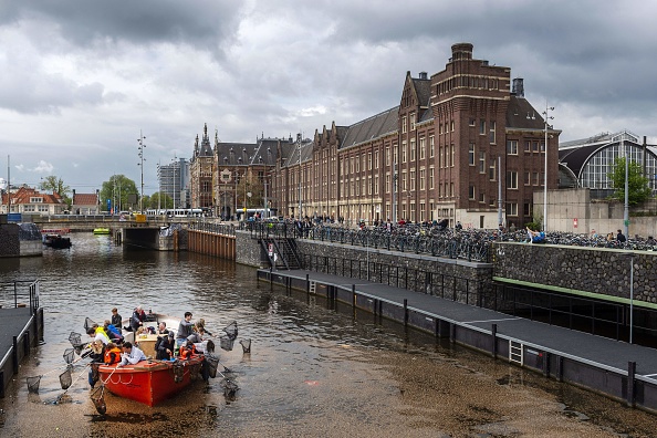 -Des bénévoles pêchent le plastique dans les canaux d’Amsterdam en participant à la fête annuelle organisée par la fondation Plastic Whale à Amsterdam, le 28 avril 2019, afin de libérer les canaux des plastiques. Photo de Evert Elzinga / ANP / AFP / Getty Images.