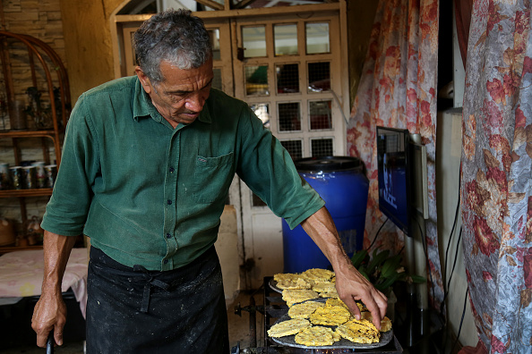 -Illustration-.Venezuela. Il y a un an, Doris Ortegano a commencé à préparer des repas pour les personnes dans le besoin à Barquisimeto, Lara. Selon ses paroles, elle a demandé à Dieu comment aider les autres et a estimé que c'était le moyen de le faire. Elle cuisine du lundi au vendredi et commence à travailler à 8 heures du matin. Ils fournissent 250 repas par jour, qui consistent en une soupe, du pain ou du riz, des repas (galette traditionnelle à base de farine de maïs blanche, eau et sel) et parfois des salades et des plantains frits. Photo par Edilzon Gamez / Getty Images.