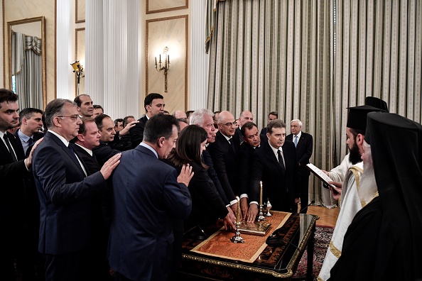 -Les nouveaux membres du gouvernement grecs prêtent serment sur la bible, comme le veut la tradition grecque, lors d'une cérémonie de nomination au palais présidentiel à Athènes le 9 juillet 2019. Photo de Louisa GOULIAMAKI / AFP / Getty Images.