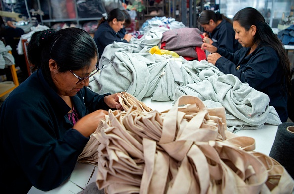 -Des femmes travaillent sur des vêtements en laine d'alpaga pour l'exportation dans un atelier à Arequipa, dans le sud du Pérou, le 8 avril 2019. L'industrie textile au Pérou est attachée à la laine d'alpaga, dont la production durable florissante génère des emplois. Photo de Cris BOURONCLE / AFP / Getty Images.