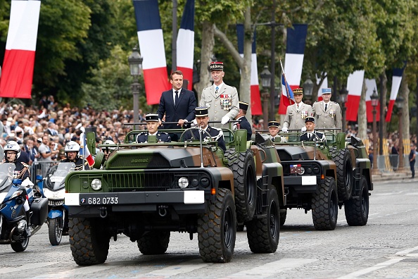 Le président Emmanuel Macron aux côtés du chef des armées le Général Francois Lecointre dans un véhicule Acmat VLRA sur les Champs-Elysées le 14 juillet 2019. (KAMIL ZIHNIOGLU/AFP/Getty Images)