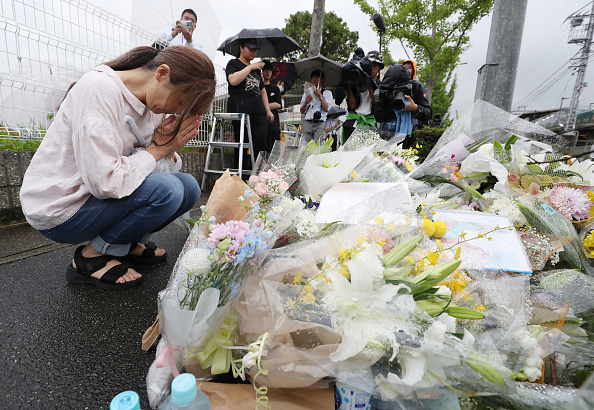 -Un habitant prie pour les victimes d'un incendie qui a frappé la veille le studio d'animation de Kyoto, faisant 34 morts. Photo par JIJI PRESS / JIJI PRESS / AFP / Getty Images.