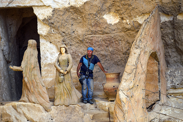 -L'artiste polonais Mario, sculpteur du complexe du monastère Saint-Simon-le-Tanneur, pose pour une photo à côté de sculptures à l'église de la capitale égyptienne, dans la partie est du district de Mokkatam, dans la partie est du Caire, le 30 mai 2019. L'artiste polonais, arrivé plus tôt en Égypte pour une mission éducative, était alors à la recherche d'une occasion de servir Dieu au monastère. Photo de Mohamed el-Shahed / AFP / Getty Images.