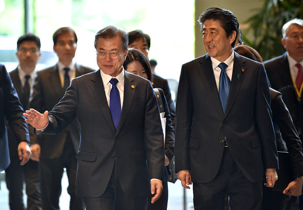 -Le président sud-coréen Moon Jae-in, serre la main du Premier ministre japonais Shinzo Abe avant leur rencontre à la résidence officielle de M. Abe à Tokyo le 9 mai 2018. Photo de Kazuhiro NOGI / POOL / AFP / Getty Images.