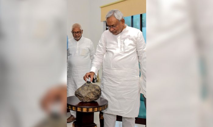 Le premier ministre du Bihar, Nitish Kumar, inspecte ce qui semble être une météorite apportée au musée Patna à Bihar, en Inde, le 24 juillet 2019. (STR/AFP/Getty Images)