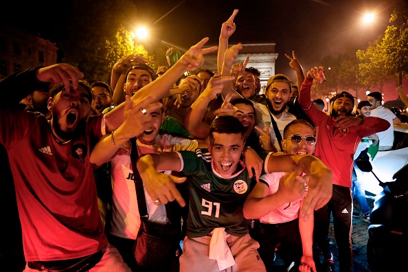 Des supporteurs de l’Algérie exultent sur les Champs-Élysées après la victoire des Fennecs en finale de la CAN le 19 juillet. Crédit : ZAKARIA ABDELKAFI/AFP/Getty Images.