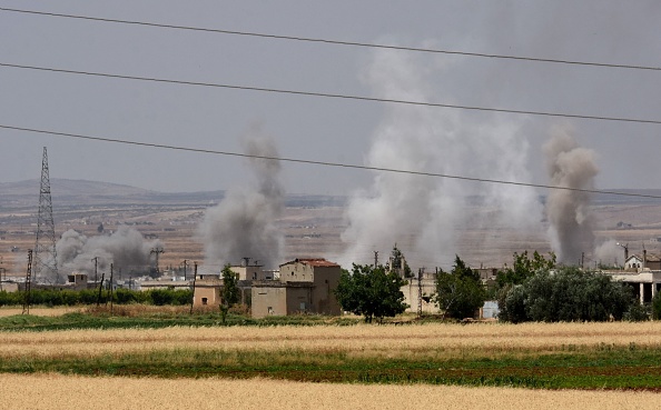 -Le village de Kfar Hod montre de la fumée qui flotte au-dessus des bâtiments alors que les forces pro-régime martèlent le village tenu par les djihadistes avec un tank et des tirs aériens lors d'affrontements entre les deux parties rivales dans le gouvernorat syrien de Hama le 9 juin 2019. Photo de George OURFALIAN / AFP / Getty Images.