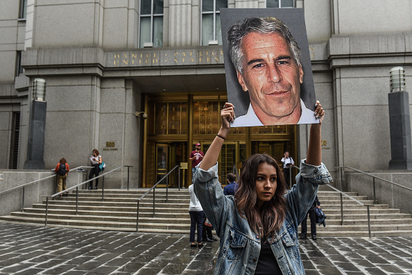 Une manifestante brandit un portrait de Jeffrey Epstein à côté du tribunal fédéral à New York, le 8 juillet 2019. (Stephanie Keith/Getty Images)