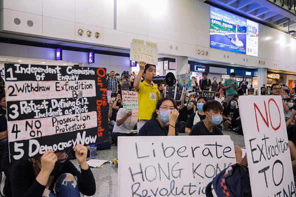 -Un jeune manifestant crie lors d’un rassemblement contre un projet de loi controversé sur l'extradition, dans le hall des arrivées de l'aéroport international le 26 juillet 2019 à Hong Kong, Chine. Photo de Billy HC Kwok / Getty Images.