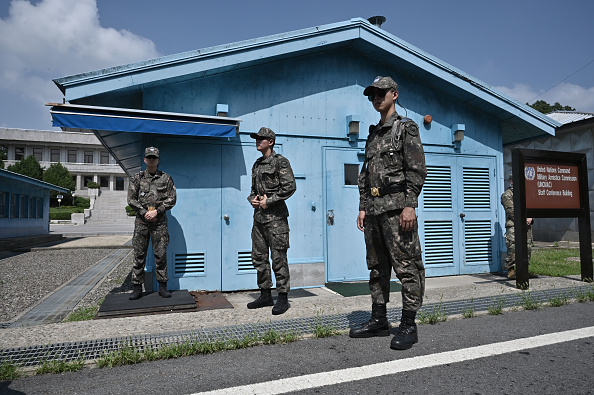 -Des soldats sud-coréens montent la garde dans le village de trêve de Panmunjom situé dans la zone démilitarisée (DMZ) divisant les deux Corées le 27 juillet 2019 après une cérémonie commémorative du 66e anniversaire de l'accord d'armistice de la guerre de Corée. Photo de Yeon-Je JUNG et JUNG YEON-JE / pool / AFP / Getty Images.