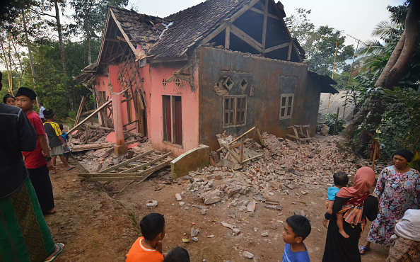 Les villageois regardent une maison sinistrée à Pandeglang, dans la province de Banten, le 3 août 2019, après qu'un puissant tremblement de terre a frappé la région.  (Photo : RONALD SIAGIAN/AFP/Getty Images)