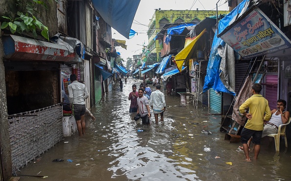 -Les résidents déambulent dans une rue inondée après les fortes pluies de mousson à Mumbai le 4 août 2019. Photo de Indranil MUKHERJEE / AFP / Getty Images.