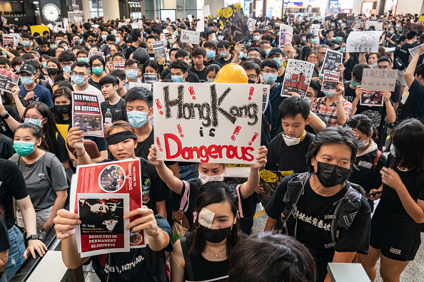 -Des manifestants occupent le hall d'arrivée de l'aéroport international de Hong Kong lors d'une manifestation le 12 août 2019 à Hong Kong, Chine. Photo par Anthony Kwan / Getty Images.