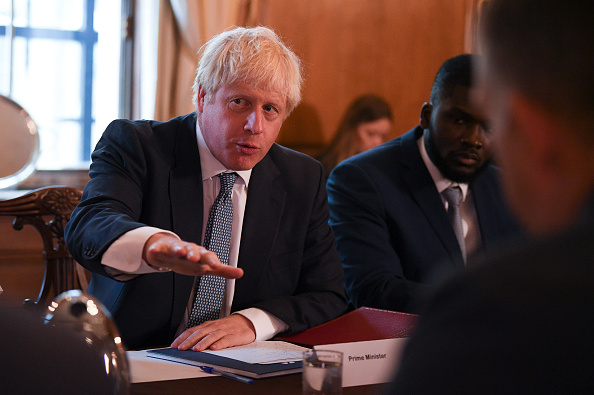 -Le Premier ministre britannique Boris Johnson parle aux côtés du conseiller du Conseil de justice pour la jeunesse, Roy Sefa-Attakora, lors d'une table ronde sur le système de justice pénale tenue le 10 août 2019 à Londres, en Angleterre. Photo de Daniel Leal-Olivas - Piscine WPA / Getty Images.