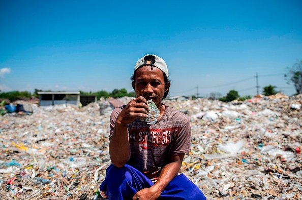 -Cette photo prise le 22 juillet 2019 montre le villageois Keman triant des déchets plastiques dans le village de Bangun. Bangun fait partie de plusieurs communautés pauvres de Java, l'île la plus peuplée d'Indonésie, qui vit des déchets venant des pays occidentaux, notamment des États-Unis, de l'Angleterre et de la Belgique, ainsi que du Moyen-Orient. Photo de JUNI KRISWANTO / AFP / Getty Images.