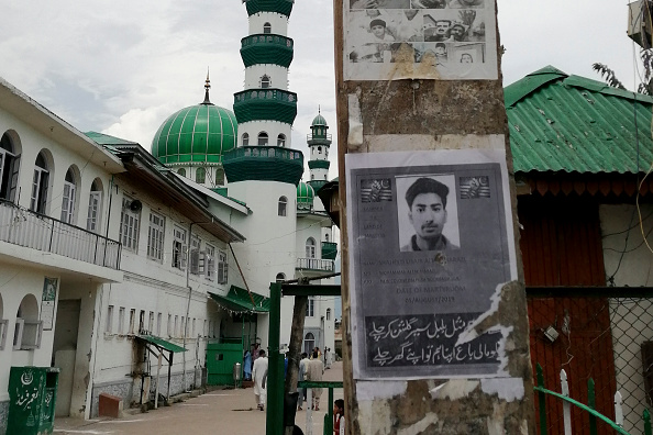 Cette photo prise le 16 août 2019 montre une affiche du jeune Cachemirien Usiab Ahmad, décédé après s'être noyé le 5 août après une supposée rencontre avec les forces gouvernementales indiennes, près de la mosquée Asar Shareef Jenab Saeb, dans la localité de Soura, à Srinagar. Photo de Jalees ANDRABI / AFP / Getty Images.