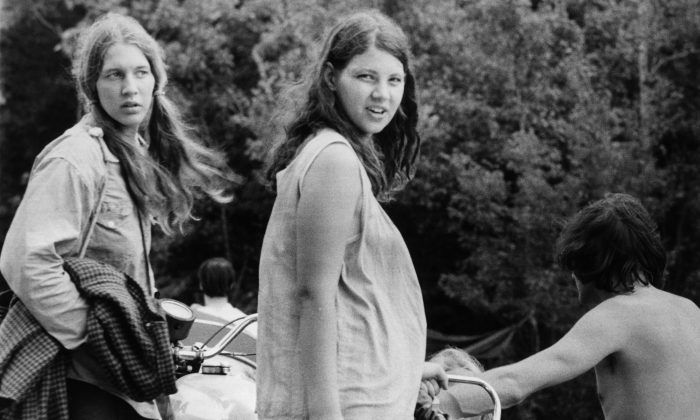 Août 1969: une femme enceinte et son amie attendent que leur motocyclette soit détachée d'une voiture alors qu'elles s'apprêtent à quitter la ferme de Max Yasgur à Bethil et le festival de musique de Woodstock. (Photo de Three Lions / Getty Images)