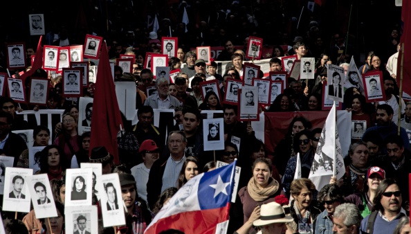 -Des militants de l'organisation chilienne de défense des droits humains "Détenus et disparus" présentent des portraits de personnes disparues pendant la dictature militaire (1973-1990) alors qu'ils participent à une manifestation à Santiago le 7 septembre 2014. Photo MARTIN BERNETTI / AFP / Getty Images.