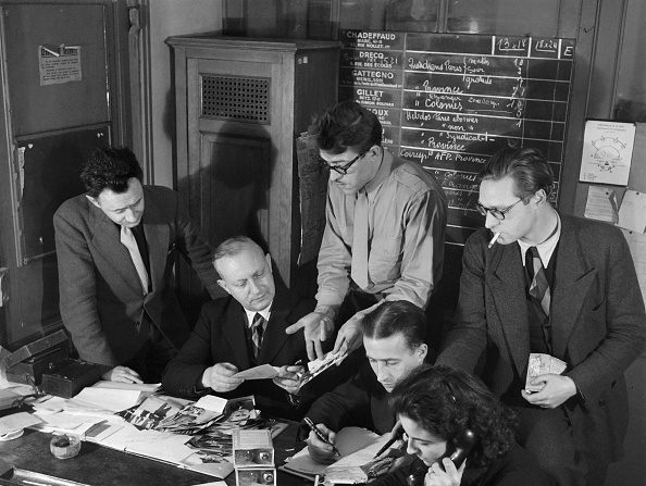 -En 1946, des journalistes, dont le directeur du service photographique de l'Agence Les reporters de l’AFP se concertent sur une sélection de reportages. Photo ERIC SCHWAB/AFP/Getty Images.
