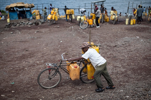 -Un homme pousse son vélo en tenant des jerricans avec de l'eau prise du lac Kivu le 24 avril 2014 à Goma. Les habitants de Goma sont obligés de boire de l'eau du lac en raison du manque d'eau courante propre et disponible. Photo FEDERICO SCOPPA / AFP / Getty Images.