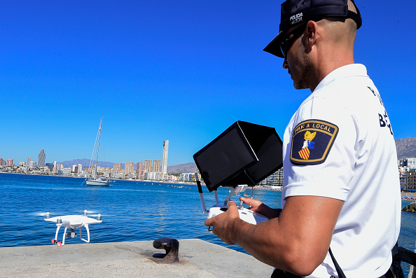 -Le policier local Agustin Mirete pilote un drone pour surveiller une plage lors d'une patrouille dans la baie de Benidorm et bientôt pour surveiller les routes et les voitures. JOSE JORDAN / AFP / Getty Images.