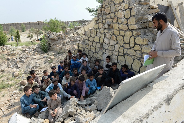 -Des écoliers afghans  dans une classe au lycée détruit. Les Etats-Unis et les Talibans affirmaient qu'ils progressaient, mais que peu de choses ont changé pour les Afghans ordinaires, et les récents attentats montrent à quel point les enfants sont aussi vulnérables. Photo par NOORULLAH SHIRZADA / AFP / Getty Images.
