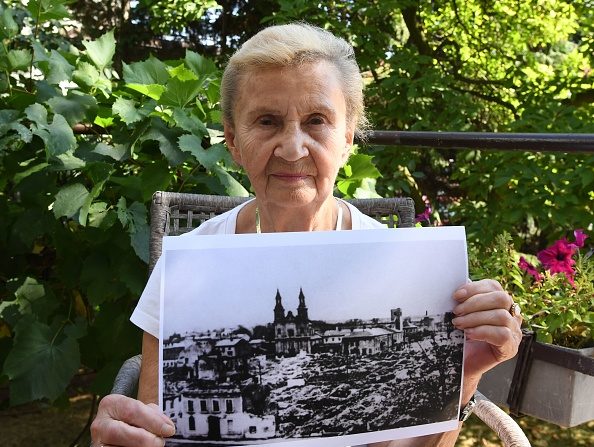 -Zofia Burchacinska, témoin oculaire du bombardement de Wielun, porte une photo de la ville détruite le 20 août 2019. L'attaque de la petite ville centrale de Wielun a été appelée une sorte de Guernica polono-juif. Photo de Janek SKARZYNSKI / AFP / Getty Images.