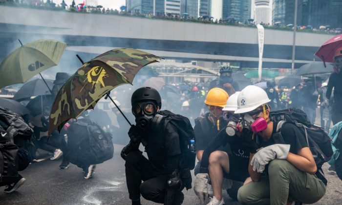 Des manifestants s'affrontent avec la police dans un nuage de gaz lacrymogène lors d'un affrontement devant le complexe du gouvernement central à Hong Kong le 31 août 2019. (Anthony Kwan/Getty Images)