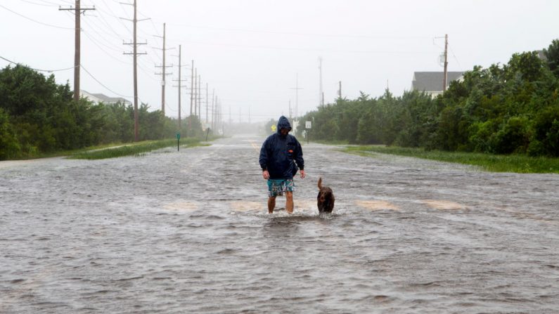 Image d'illustration - Bryan Philips marche avec son chien le long d'une route inondée à Salvo, en Caroline du Nord, alors que l'ouragan Dorian frappe cet État le 6 septembre 2019. (JOSE LUIS MAGANA/AFP/Getty Images)