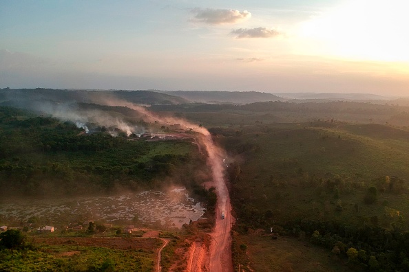 Dans cette vue aérienne, la poussière rouge de la route BR230, appelée "Transamazonica", se mêle aux incendies au coucher du soleil dans la ville agricole de Ruropolis, dans l'État de Para, au nord du Brésil, le 6 septembre 2019. (Photo : JOHANNES MYBURGH/AFP/Getty Images)