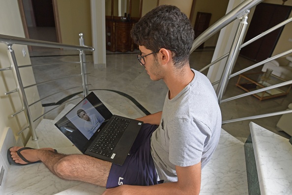 -Le Tunisien Mohamed Ghedira, 25 ans, navigue sur une nouvelle plate-forme en ligne (Quel est votre programme ?). Photo de FETHI BELAID / AFP / Getty Images.