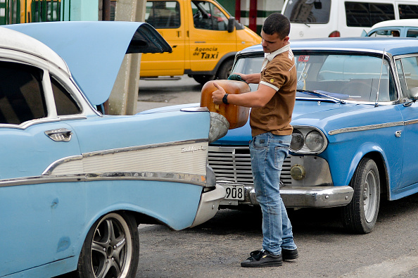 Un homme utilise un entonnoir pour remplir sa voiture avec de l'essence dans une rue de La Havane, le 12 septembre 2019.(Photo : YAMIL LAGE/AFP/Getty Images)