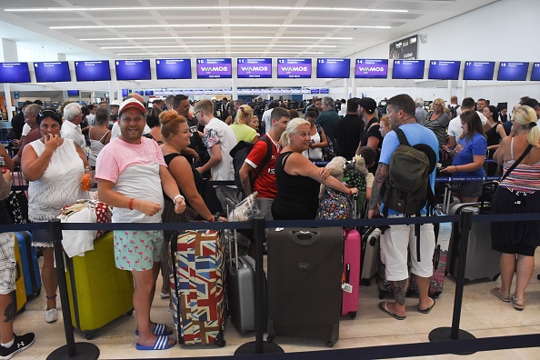 Les passagers font la queue au comptoir d'enregistrement fermé de Thomas Cook à l'aéroport international de Cancun, au Mexique, le 23 septembre 2019. La faillite du voyagiste britannique Thomas Cook aura un impact important sur les stations balnéaires de Mexicos Caribbean, ont annoncé lundi les autorités. (Photo : ELIZABETH RUIZ/AFP/Getty Images)