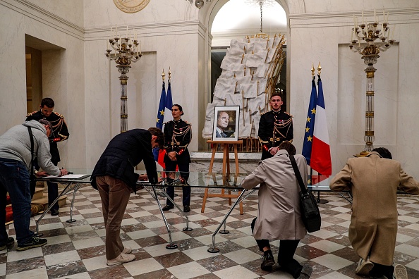 -Des personnes signent les registres de condoléances de l'ancien président français Jacques Chirac au Palais présidentiel de l'Elysée à Paris le 26 septembre 2019, après l'annonce de son décès à l'âge de 86 ans. Photo de GEOFFROY VAN DER HASSELT / AFP / Getty Images.