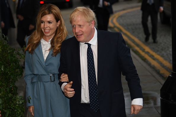 -Le 28 septembre 2019, le Premier ministre britannique Boris Johnson se promène avec sa partenaire Carrie Symonds au Midland, près du complexe des congrès de Manchester Central, à la veille de la conférence annuelle du Parti conservateur. Photo par OLI SCARFF / AFP / Getty Images.