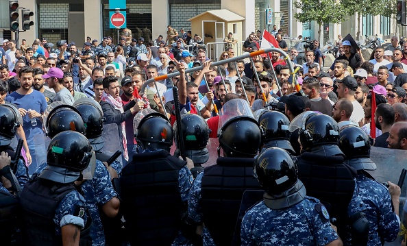 Des manifestants libanais se heurtent à des policiers anti-émeute alors qu'ils tentent de franchir les barrières de sécurité devant le bureau du gouvernement lors d'une manifestation sur la Place des Martyrs à Beyrouth, le 29 septembre 2019.  Des centaines de personnes ont manifesté aujourd'hui dans la capitale libanaise pour protester contre une pénurie de dollars et éventuelles hausses de prix. (Photo : ANWAR AMRO/AFP/Getty Images)