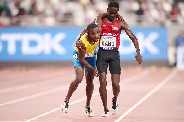 Braima Suncar Dabo, de Guinée-Bissau, aide Jonathan Busby, d'Aruba, à franchir la ligne d'arrivée aux Championnats du monde d'athlétisme de l'IAAF, Doha 2019, au stade international Khalifa, à Doha, Qatar. (Photo : Christian Petersen/Getty Images)