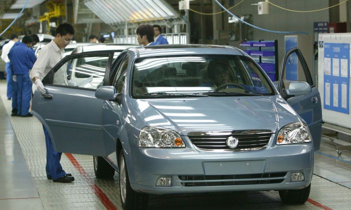 Des ouvriers travaillent sur une ligne d’assemblage de voitures Buick Excelles à l'usine Jinqiao South Vehicle Plant de Shanghai General Motors Corp. à Shanghai, Chine, le 28 mai 2005. (China Photos/Getty Images)