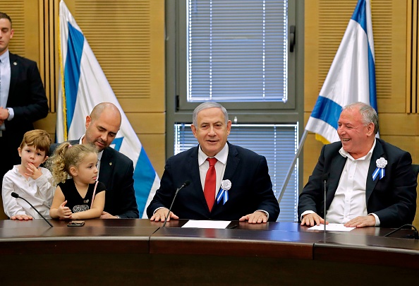 -Le Premier ministre israélien Benjamin Netanyahu s'exprime aux côtés du ministre de la Justice, Amir Ohana et de ses enfants, lors d'une réunion des membres du Likoud au Knesset à Jérusalem le 3 octobre 2019. Photo de EMMANUEL DUNAND / AFP / Getty Images.