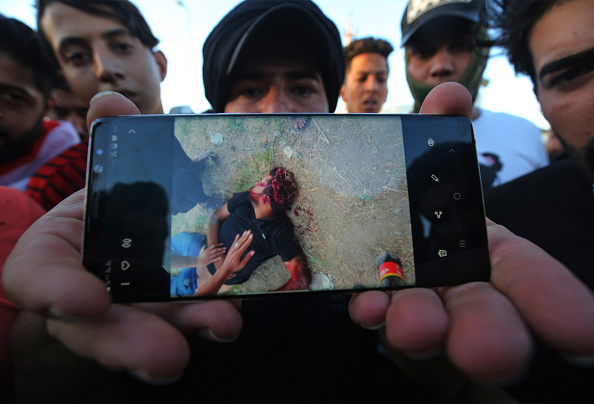 Un manifestant irakien affiche sur son téléphone l'image d'un autre manifestant qui aurait été tué aujourd'hui, lors d'une manifestation contre la corruption de l'État, la défaillance des services publics et le chômage, sur la place centrale Khellani de la capitale irakienne, Bagdad, le 4 octobre 2019. (Photo  : AHMAD AL-RUBAYE/AFP via Getty Images)