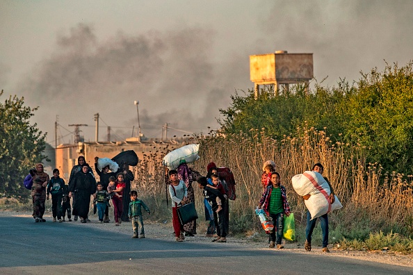 Des civils fuient avec leurs biens durant les bombardements turcs sur la ville de Ras al-Ain, dans le nord-est de la Syrie, dans la province de Hasakeh, le long de la frontière turque, le 9 octobre 2019. (Photo : DELIL SOULEIMAN/AFP via Getty Images)