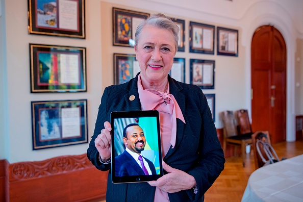-La présidente du comité norvégien du prix Nobel de la paix, Berit Reiss-Andersen, pose avec une photo du Premier ministre éthiopien Abiy Ahmed dans l'institut Nobel à Oslo le 11 octobre 2019. Photo de Stian Lysberg Solum / NTB Scanpix / AFP / Getty Images.