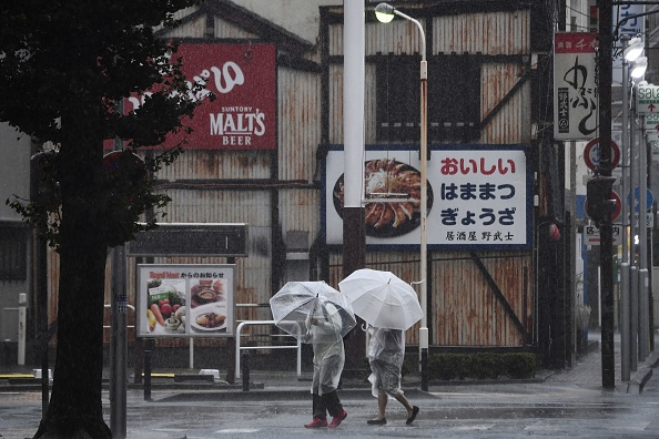 Les piétons utilisent des parapluies pour se protéger de la pluie alors qu'ils marchent dans une rue de Hamamatsu, dans la préfecture de Shizuoka, le 12 octobre 2019, alors que le pays se prépare pour le débarquement du typhon Hagibis. 
 (Photo : ANNE-CHRISTINE POUJOULAT/AFP via Getty Images)