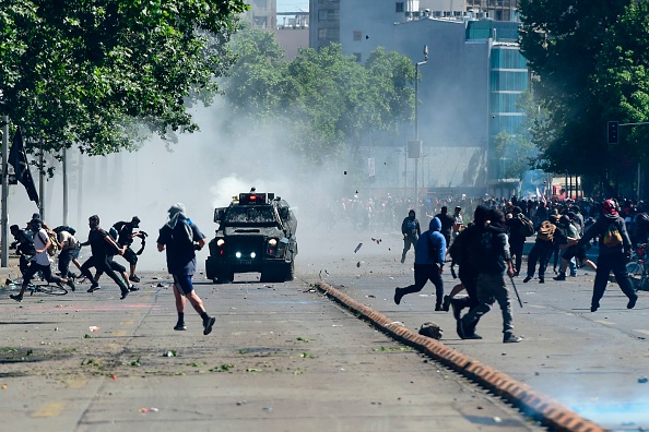 Des manifestants se heurtent à la police anti-émeute lors d'une manifestation à Santiago du Chili, le 21 octobre 2019. (Photo : MARTIN BERNETTI/AFP via Getty Images)