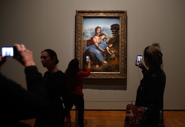-Les gens prennent des photos d’un tableau de "La Vierge avec l'enfant de sainte Anne" de Léonard de Vinci, lors de l'inauguration de l'exposition "Léonard de Vinci", le 22 octobre 2019 au musée du Louvre à Paris. Photo FRANCOIS GUILLOT / AFP via Getty Images.