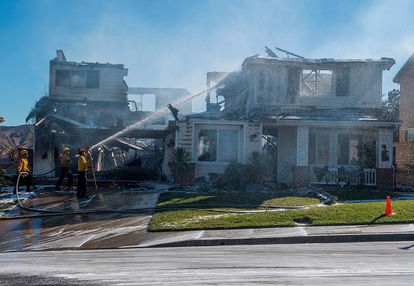 Les pompiers arrêtent le feu d'une maison  lors de l'incendie à Agua Dulce près de Santa Clarita, en Californie, le 25 octobre 2019.( Photo : MARK RALSTON/AFP via Getty Images)