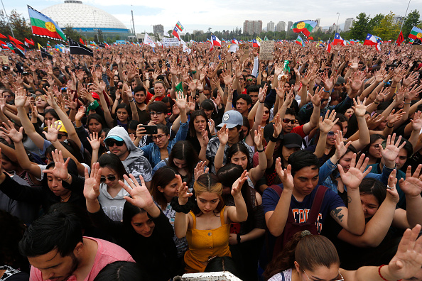 Les manifestants lèvent la main pendant une minute de silence pour les personnes décédées lors des manifestations sur la Plaza O'Higgins le 27 octobre 2019 à Santiago du Chili,(Photo : Marcelo Hernandez/Getty Images)