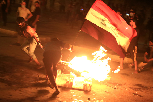 Des manifestants irakiens brûlent des objets pour bloquer la route alors qu'ils se heurtent aux forces de sécurité lors d'une manifestation antigouvernementale dans la ville chiite de Karbala, au sud de la capitale irakienne, Bagdad, le 27 octobre 2019. (Photo : AFP via Getty Images)