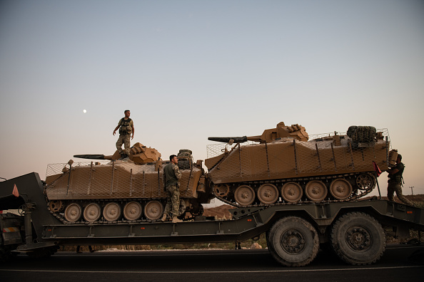 Des soldats turcs préparent des véhicules blindés avant de traverser la frontière syrienne le 9 octobre 2019 à Akcakale, en Turquie. (Photo : Burak Kara/Getty Images)